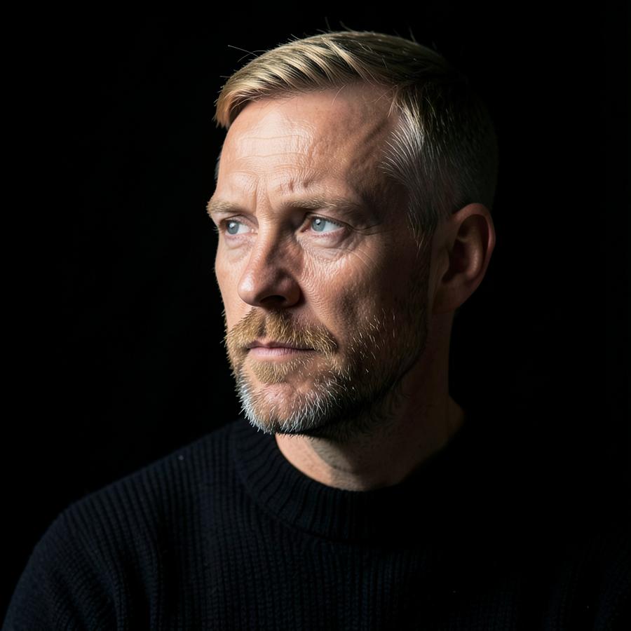 Porträtt av Fredrik Jonsson i dämpat sidoljus mot mörk bakgrund
